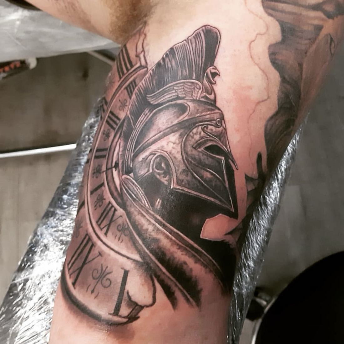 Tattoo: Black & grey realism — Spartan helmet and watch